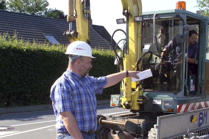 Arbeiter vor Baggerfahrer