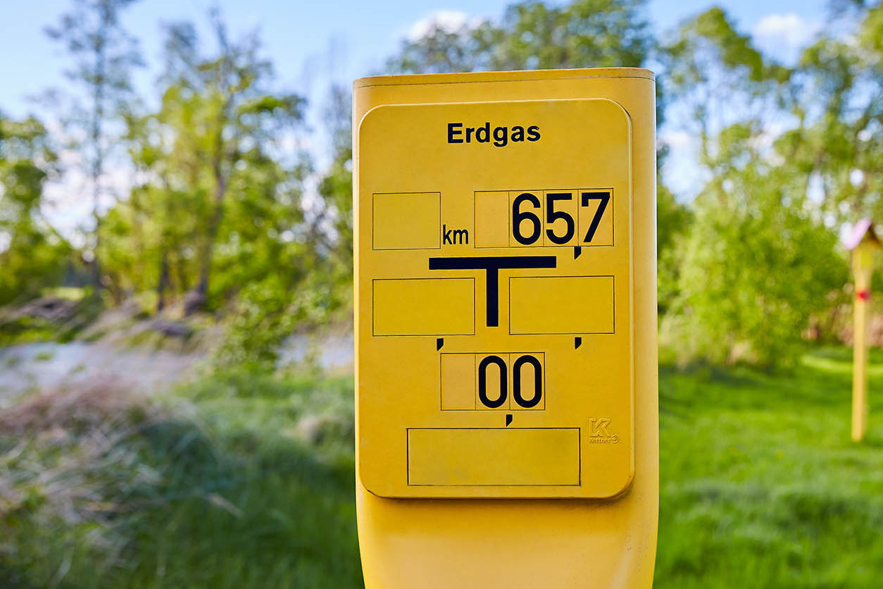 Schilderpfähle markieren den Verlauf einer Erdgasleitung