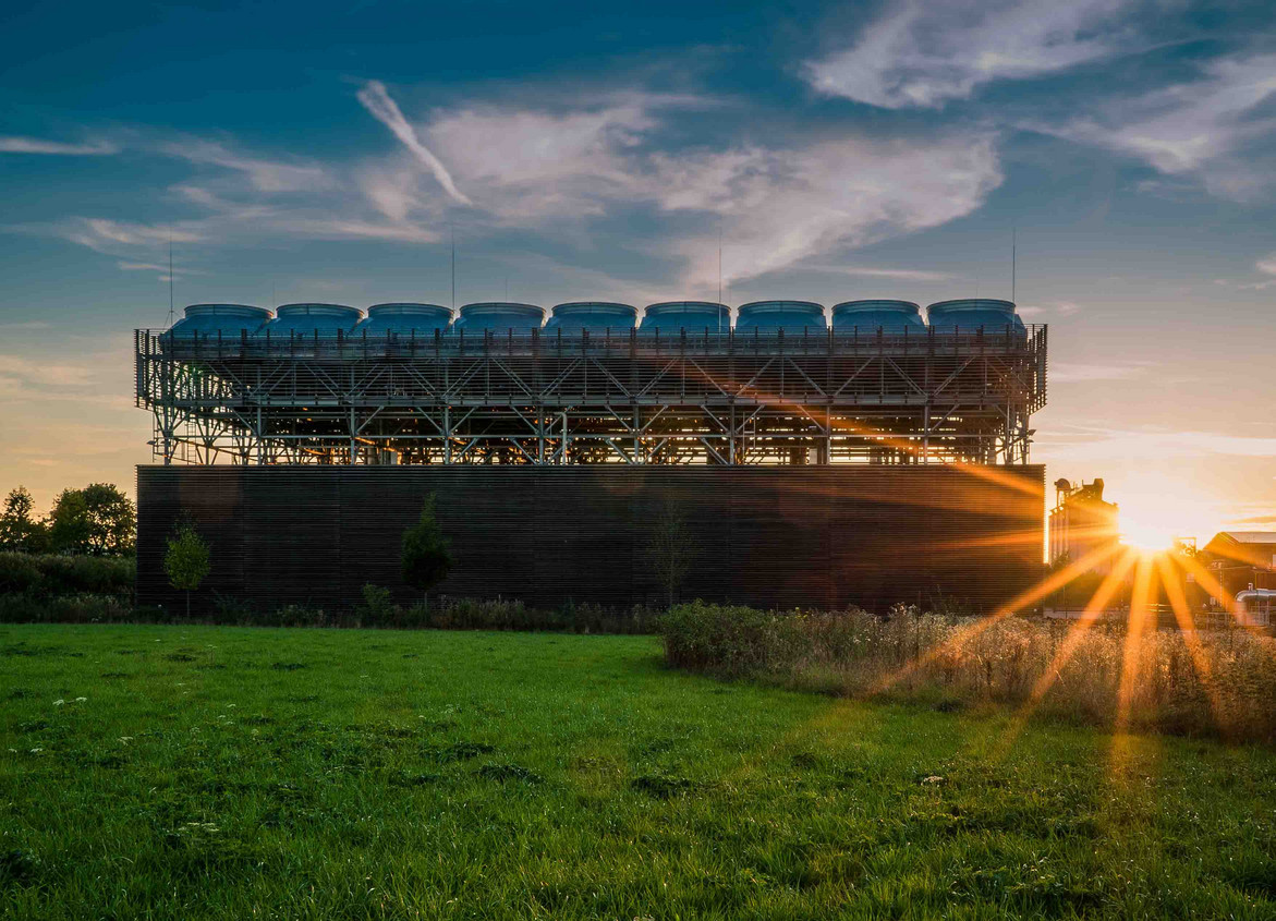 Die Anlage steht auf einem Feld, von schräg unten fotografiert, in der Abendsonne