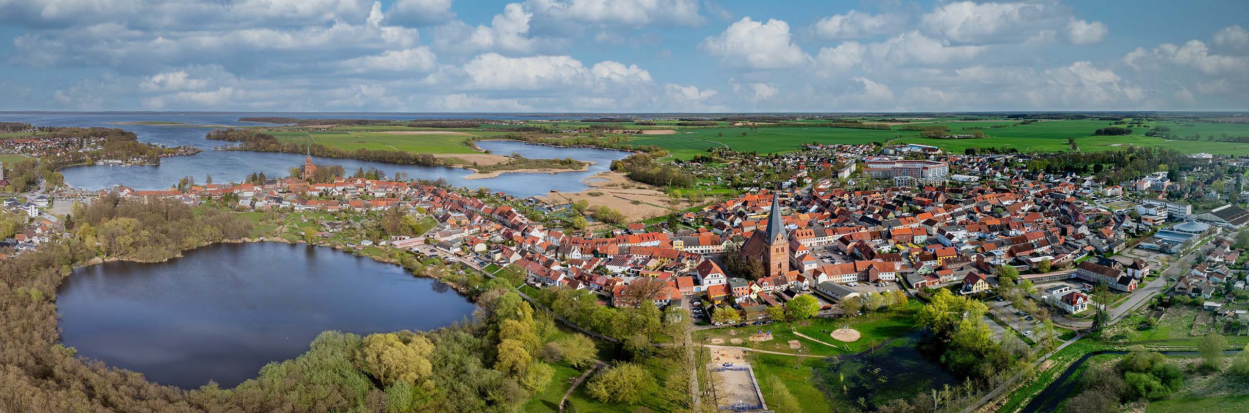 Luftaufnahme einer Kleinstadt am Rande einer Seenplatte